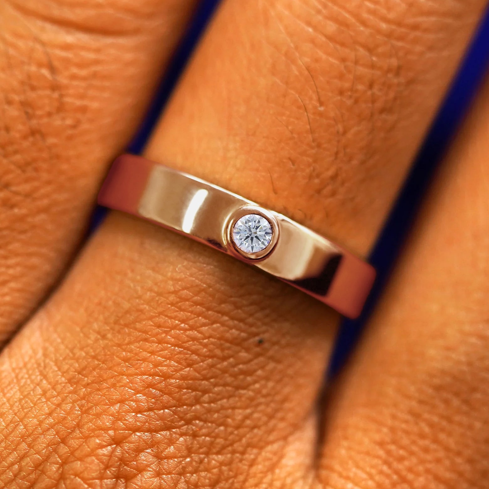 Close up view of a model's fingers wearing a 14k rose gold Diamond Industrial Band