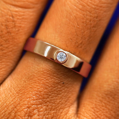 Close up view of a model's fingers wearing a 14k rose gold Diamond Industrial Band