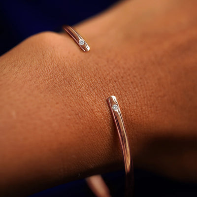 A model's wrist wearing a rose gold Diamond Open Bangle Bracelet