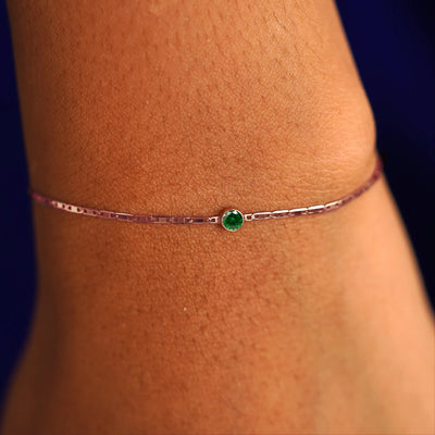 A model's wrist wearing a 14 karat rose gold Emerald Bracelet