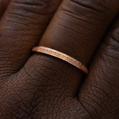 Close up view of a model wearing a solid 14k rose gold geometric grass band