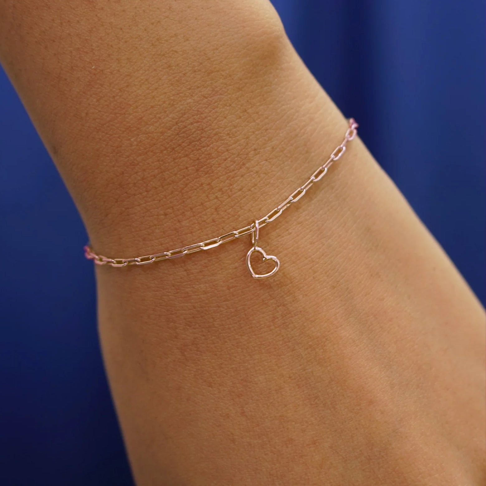 Close up view of a model's wrist wearing a rose gold Heart Charm on a Butch Bracelet