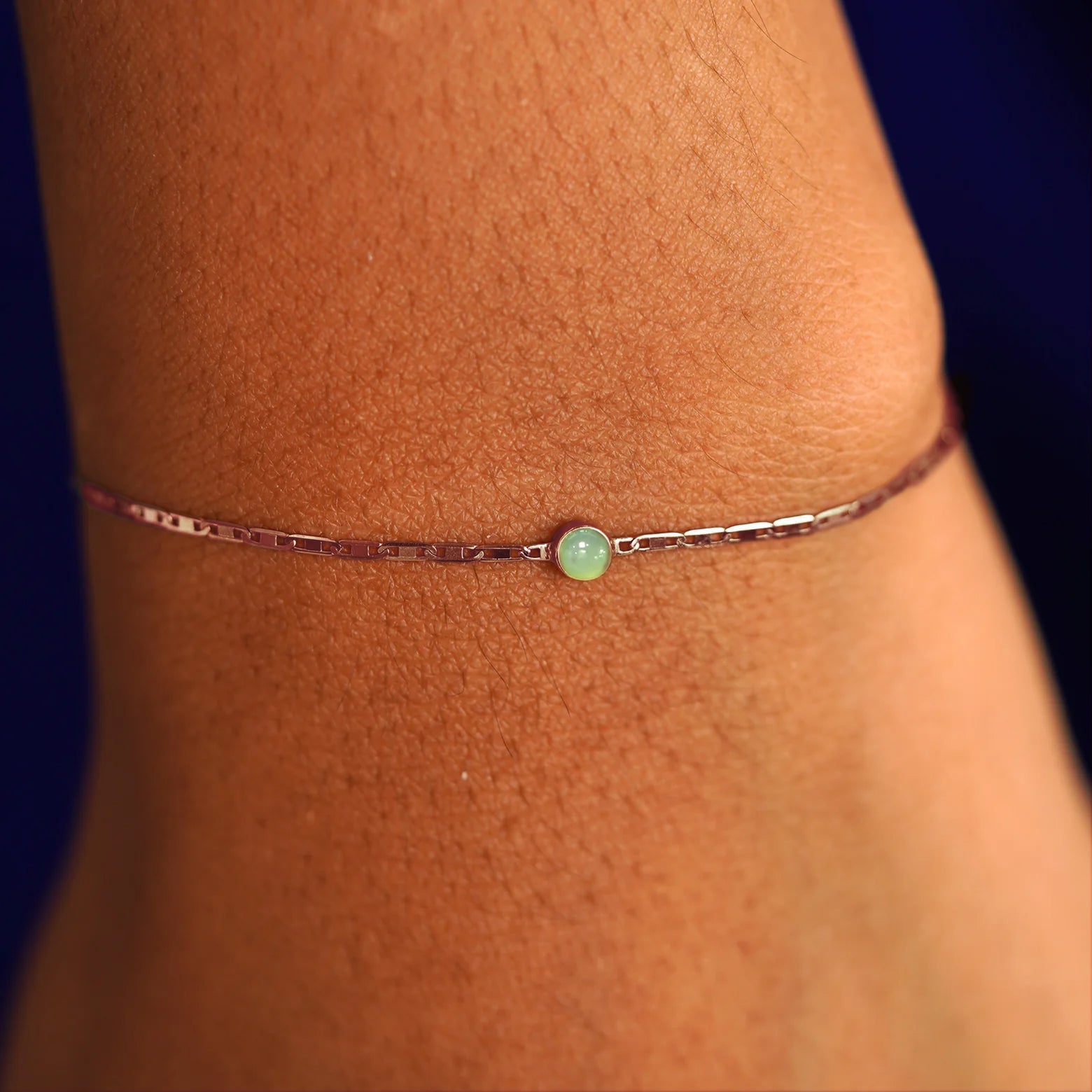 A model's wrist wearing a solid 14k rose gold Jade Bracelet