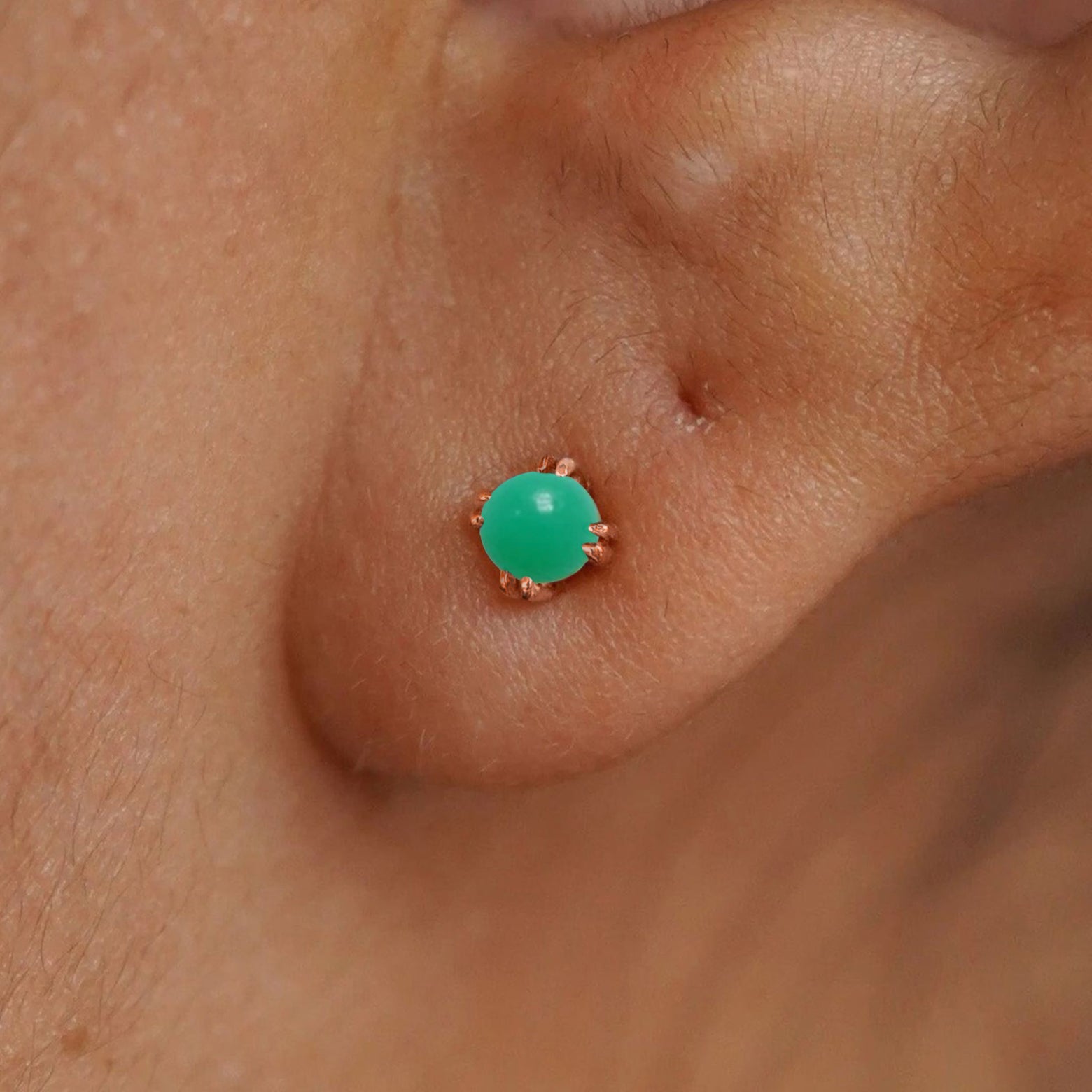 Close up view of a model's ear wearing a 14k rose gold Green Jade Earring