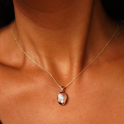 Close up view of a model's neck wearing a rose gold Oval Locket Pendant on a Cable Chain