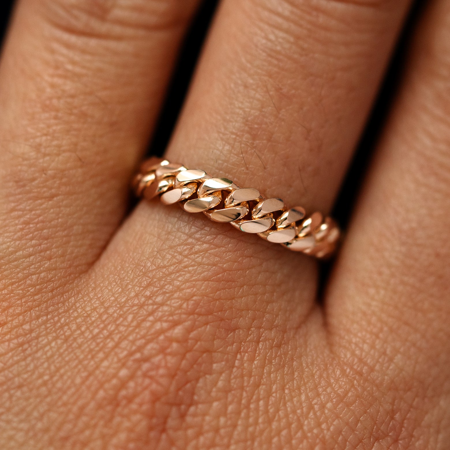 Close up view of a model's fingers wearing a 14k rose gold Medium Miami Ring