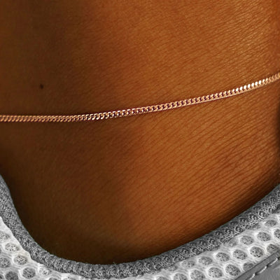 Close up view of a model's ankle wearing a solid rose gold Mini Miami Anklet
