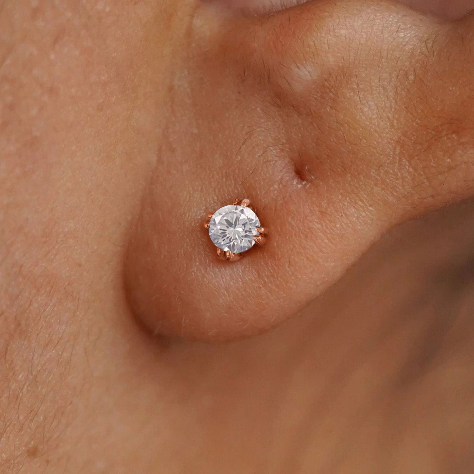 Close up view of a model's ear wearing a 14k yellow gold Moissanite Stud Earring