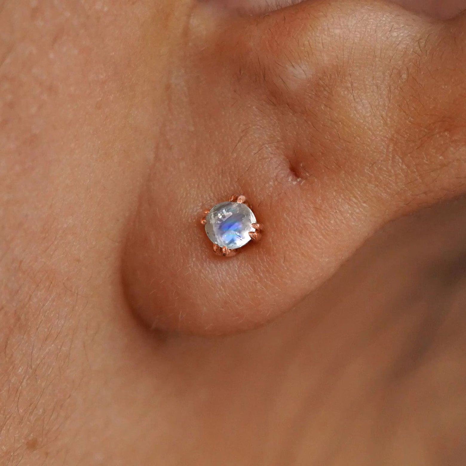 Close up view of a model's ear wearing a 14k rose gold Moonstone Earring