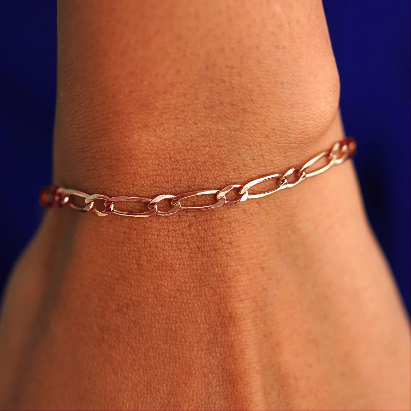 A model's wrist wearing a rose gold One to One Chain Bracelet