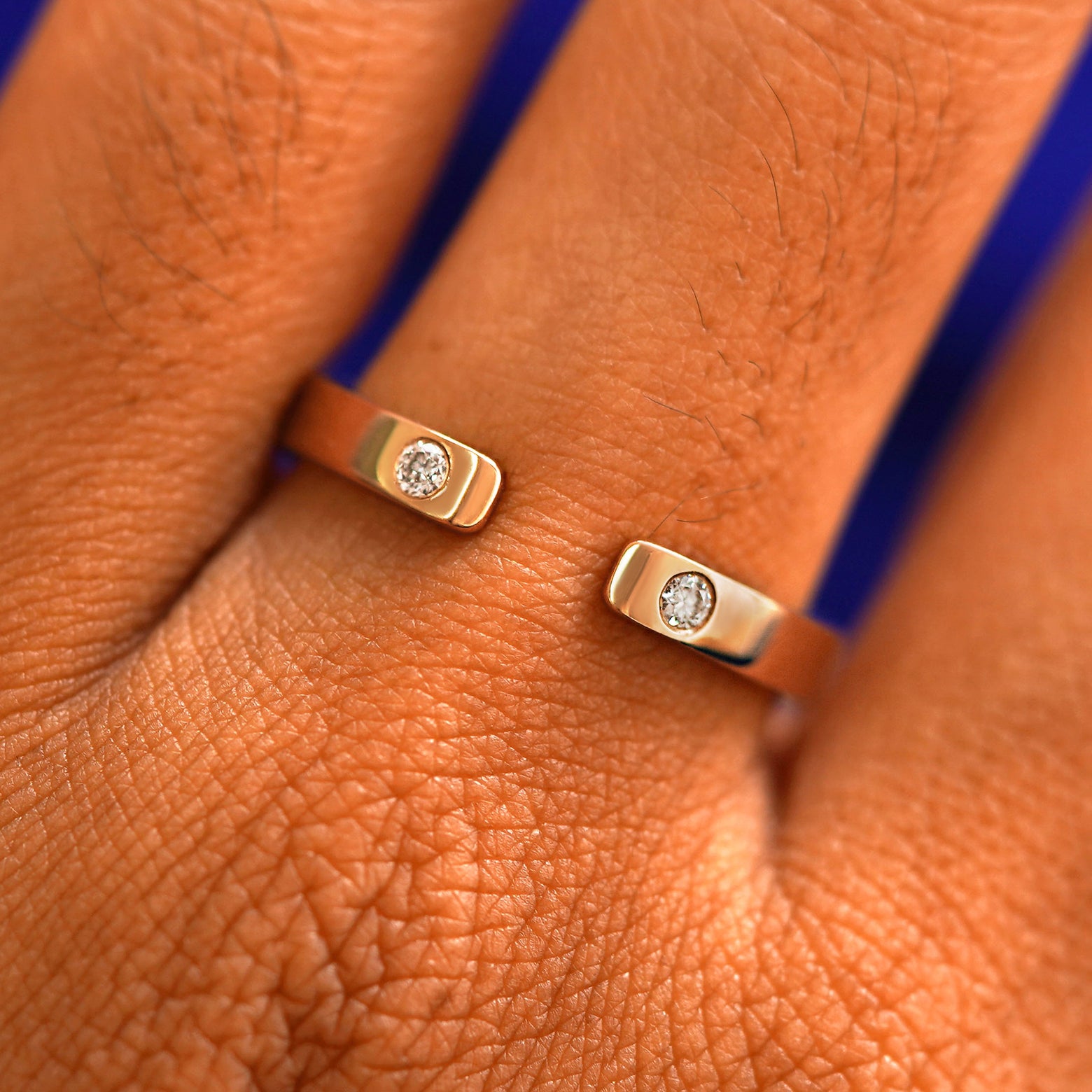 Close up view of a model's fingers wearing a 14k rose gold Open Industrial Band