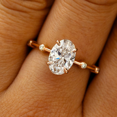 A solid 14k rose gold Oval Lab Diamond Bubble Ring on a model's finger