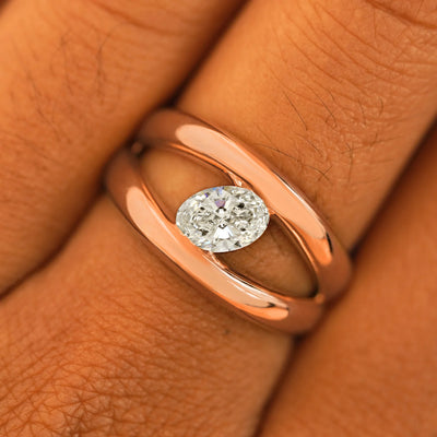 Close up view of a model's fingers wearing a 14k rose gold Oval Lab Diamond Tension Ring