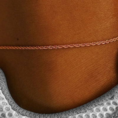 Close up view of a model's ankle wearing a rose gold Rope Anklet
