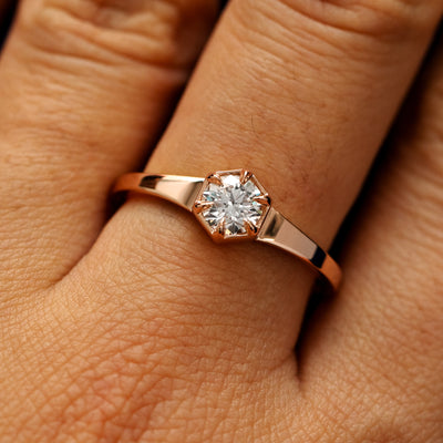 Close up view of a models fingers wearing a 14k rose gold round diamond hexagon signet ring