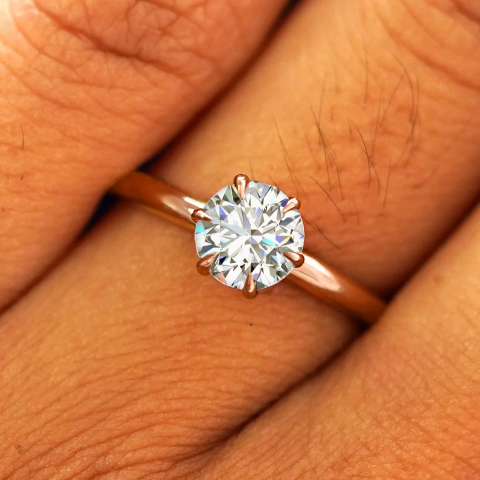 Close up view of a model's fingers wearing a 14k rose gold Round Lab Diamond Ring