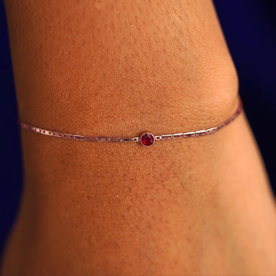 A model's wrist wearing a 14 karat rose gold Ruby Bracelet