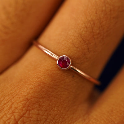 Close up view of a model's hand wearing a rose gold Ruby Ring