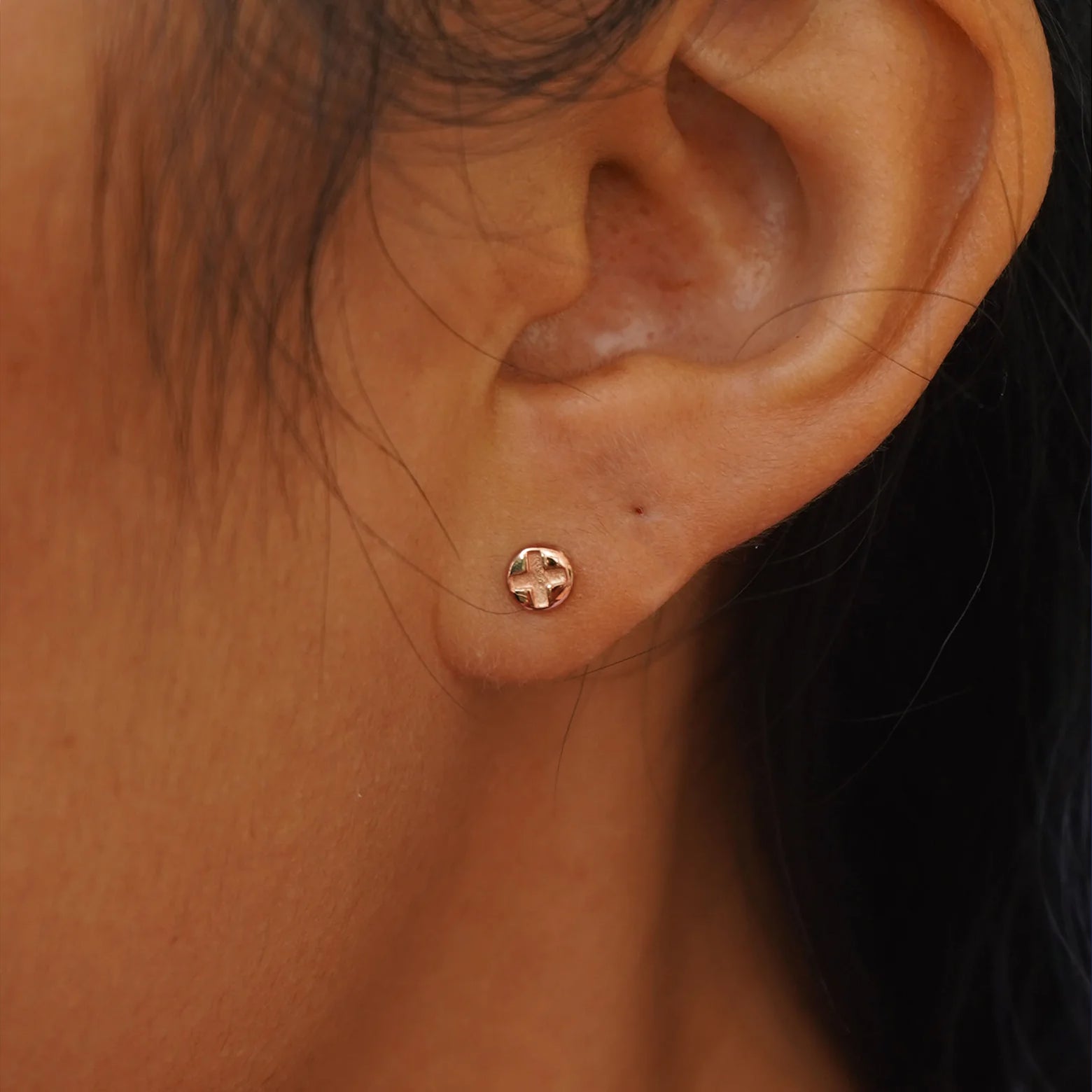 A model's ear wearing a rose gold Screw Earring