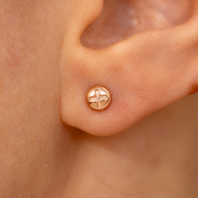 Close up view of a model's ear wearing a rose gold Screw Earring