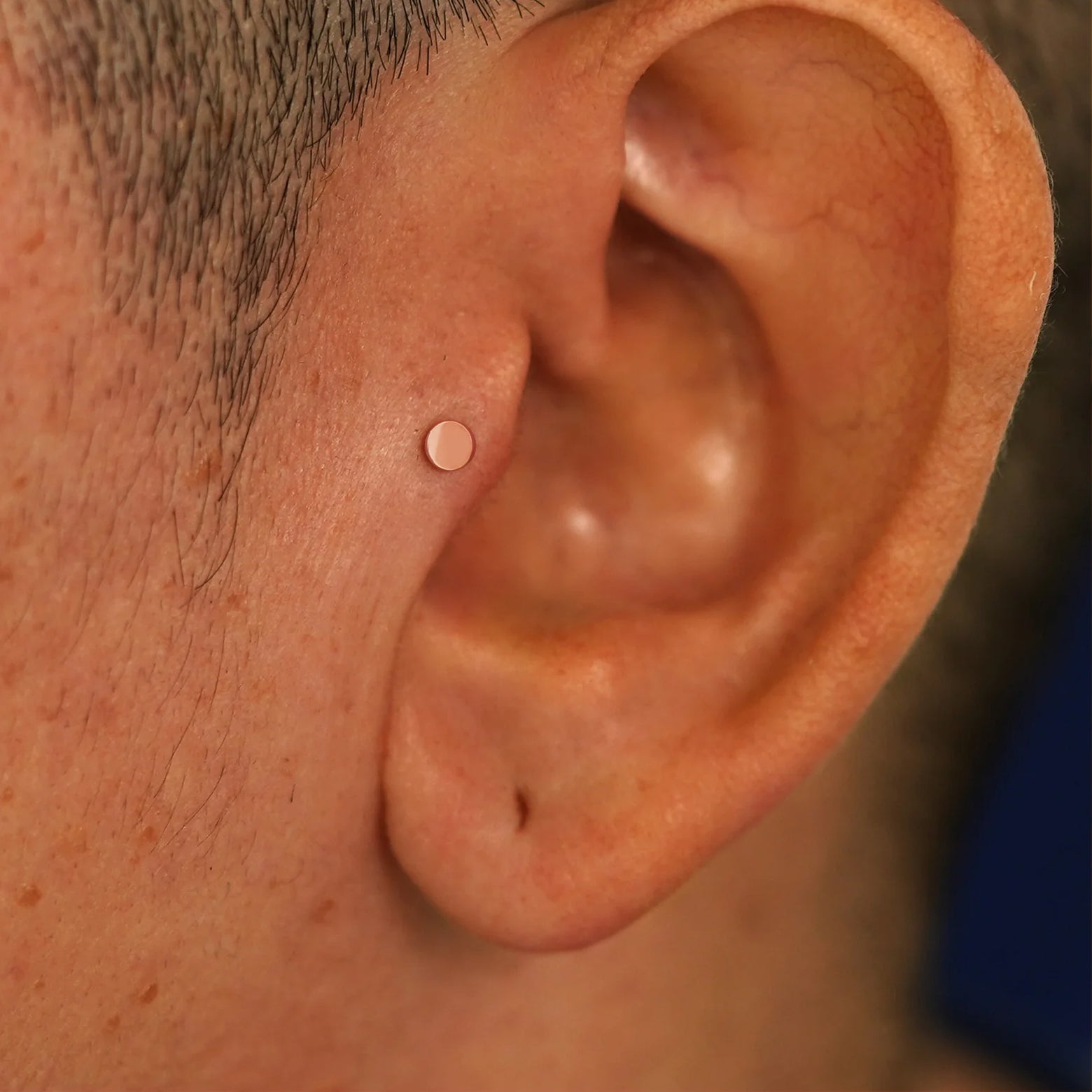 A model's ear wearing a 14k rose gold Small Circle Flatback in a tragus piercing