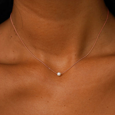 A model's neck wearing a rose gold Pearl Slide Necklace with a 4mm pearl