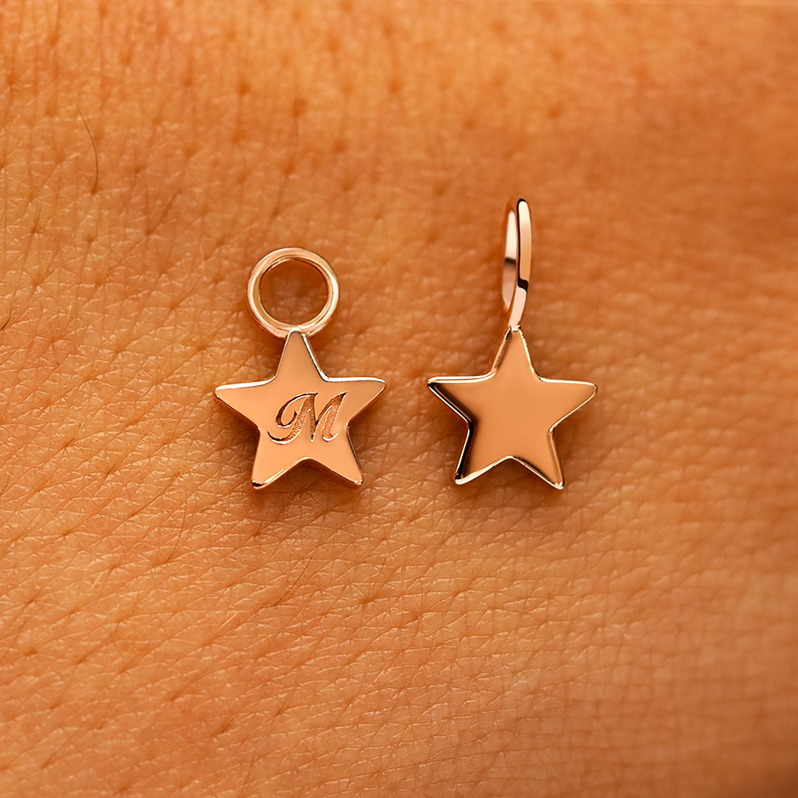 Two solid 14k rose gold Star Charms showing the for chain and the for earring options