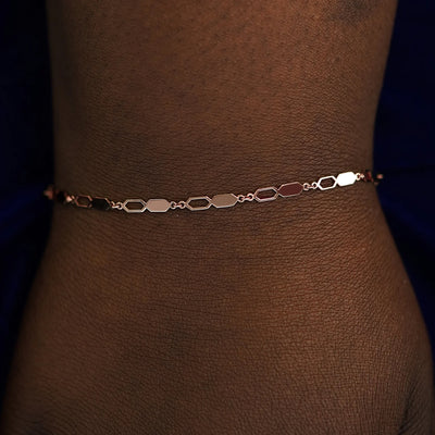A model's wrist wearing a solid rose gold Tanlah Bracelet