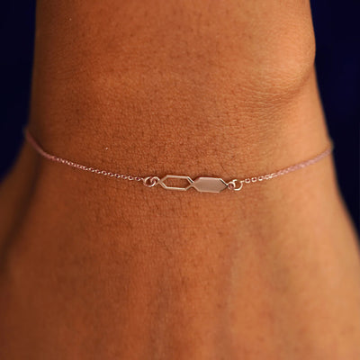 Close up view of a model's wrist wearing a solid rose gold Tanlah Cable Bracelet