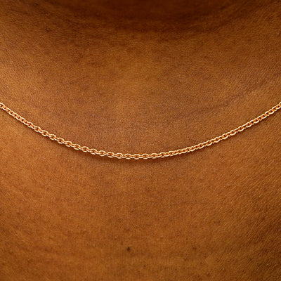 Close up view of a model's neck wearing a solid 14k rose gold Thick Cable Chain