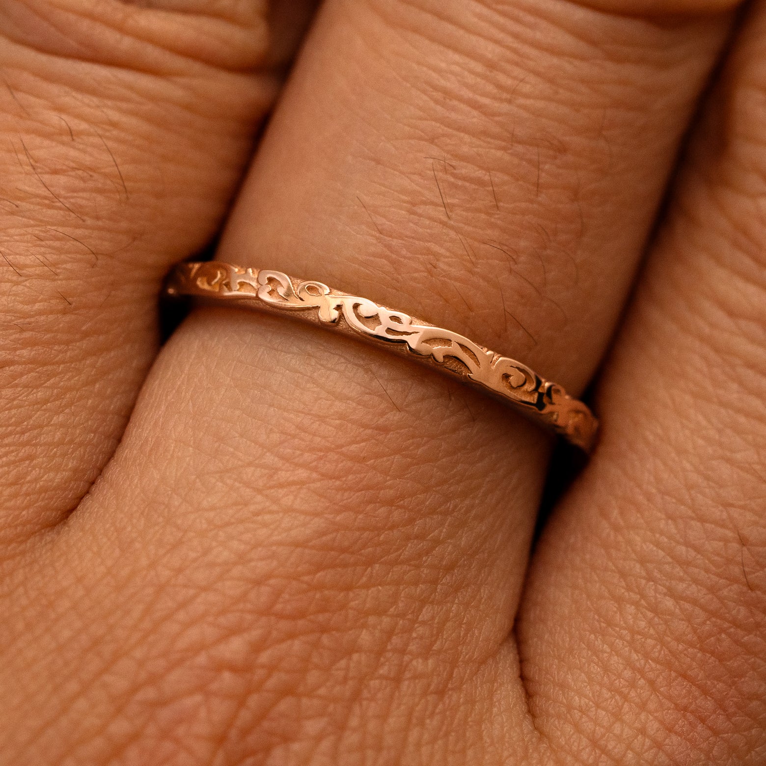 Close up view of a model's fingers wearing a 14k rose gold Thin Filigree Band