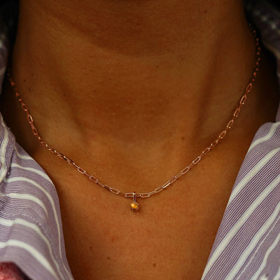 Close up view of a model's neck wearing a rose gold Tiger Eye Charm on a Butch Chain