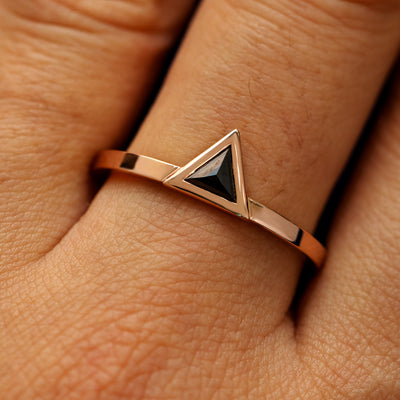 Close up view of a model's hand wearing a solid 14k rose gold Triangle Diamond Ring