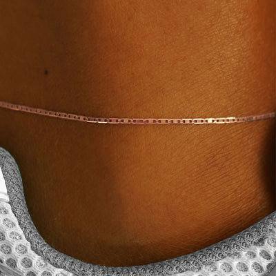 Close up view of a models ankle wearing a 14k rose gold Valentine Anklet