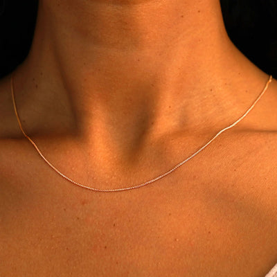 Close up view of a model's neck wearing a solid 14k rose gold Wheat Chain