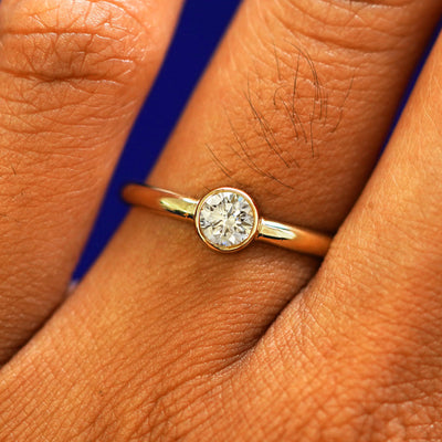 Close up view of a model's fingers wearing a 14k yellow gold Lab Clear Diamond Ring