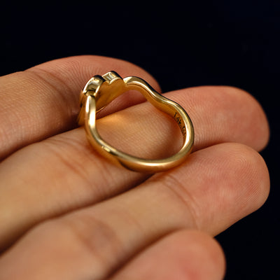 A Heart Salt and Pepper Diamond Infinite Wave Ring in a model's hand showing the underside of the stones