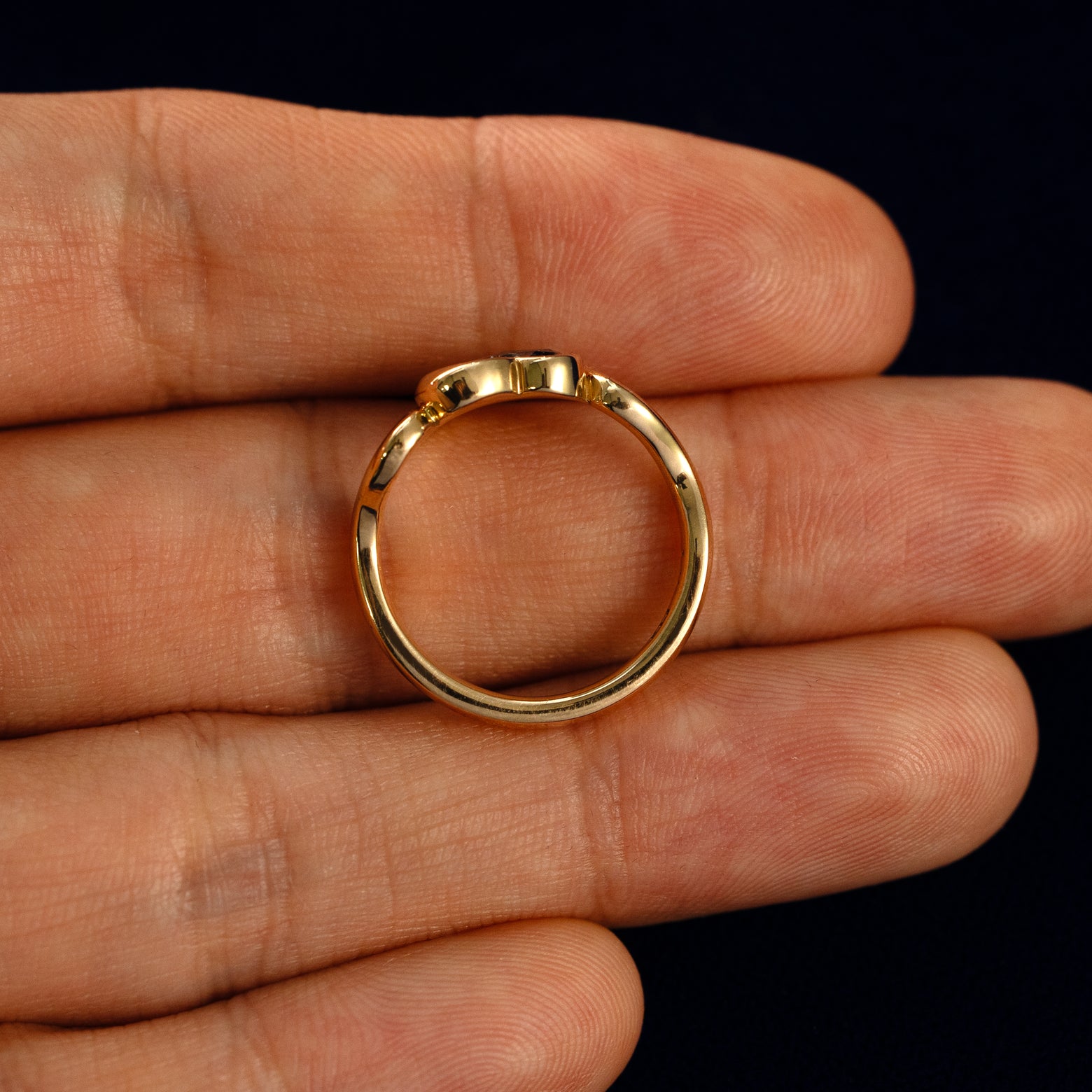 A Heart Salt and Pepper Diamond Infinite Wave Ring in a model's hand showing the thickness of the band
