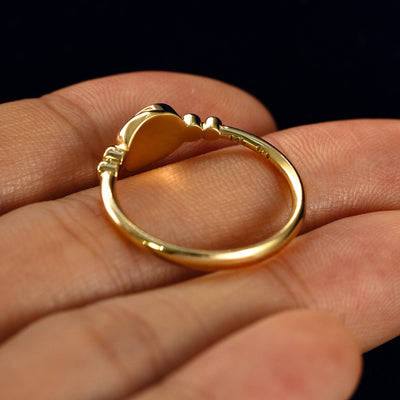 A Rose Cut Salt and Pepper Diamond Moon Ring in a model's hand showing the underside of the stones