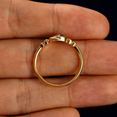 A Rose Cut Salt and Pepper Diamond Moon Ring in a model's hand showing the thickness of the band