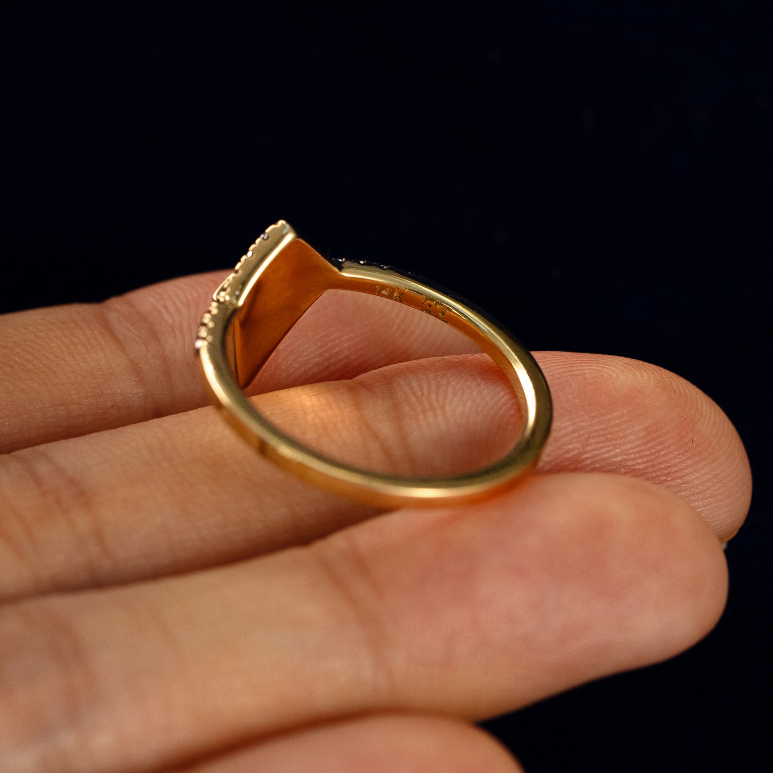 A Kite Salt and Pepper Diamond Pave Chevron Ring in a model's hand showing the underside of the stones