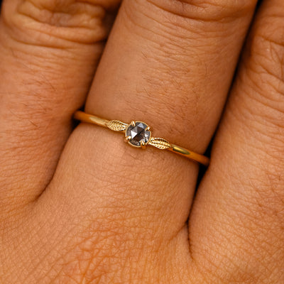 A solid 14k yellow gold Salt and Pepper Diamond Two Leaf Ring on a model's finger