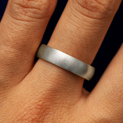 Close up view of a model's fingers wearing a 4mm 925 silver Curvy Matte Band