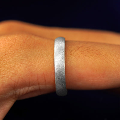 Side view of a Sterling Silver Curvy Stardust Band on a model's finger