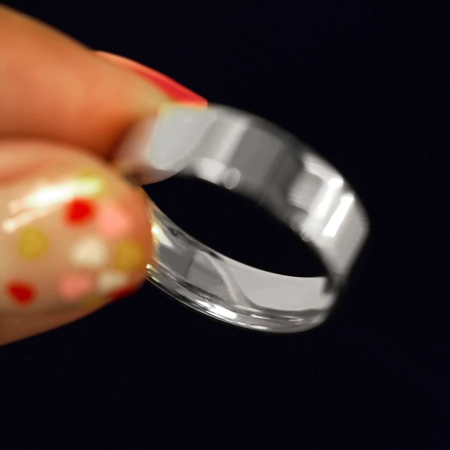 A model holding a 925 Silver Industrial Mirror Band tilted to show the inside of the band