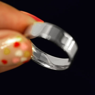 A model holding a 925 Silver Industrial Mirror Band tilted to show the inside of the band