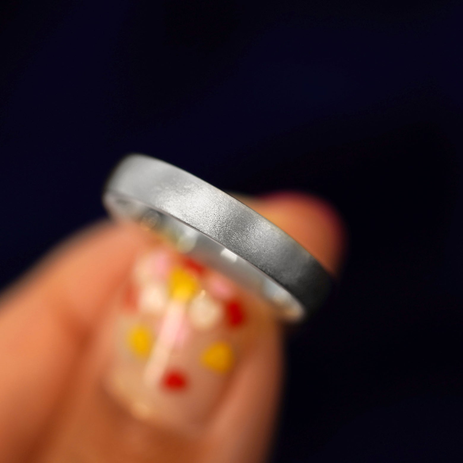A model holding a Silver Mix Matte Band tilted to show the side of the ring