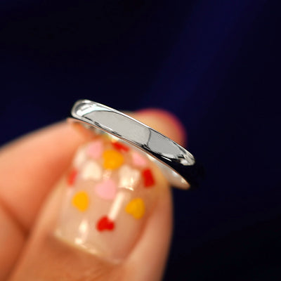 A model holding a 925 Silver Mix Mirror Band tilted to show the side of the ring