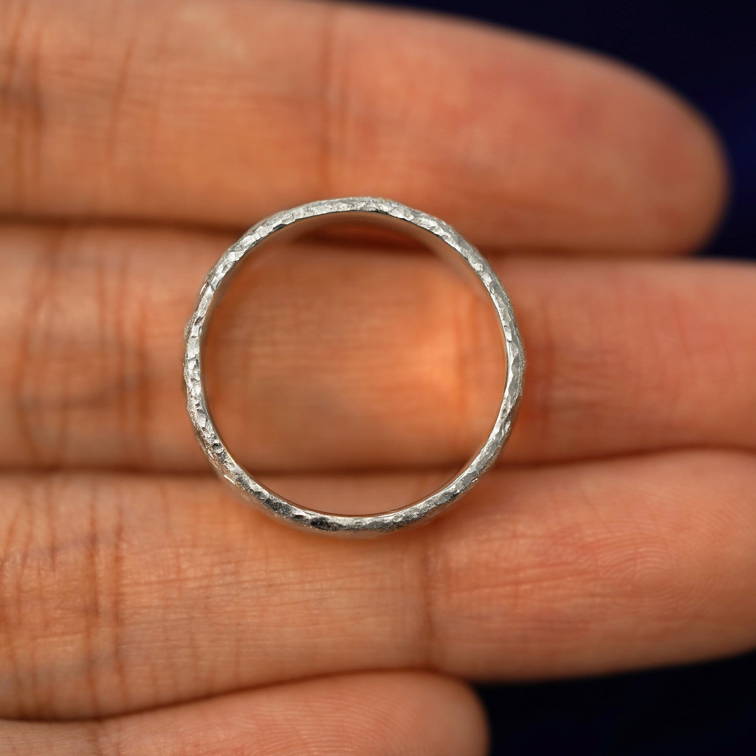 A silver Mix Organic Band in a model's hand showing the thickness of the band