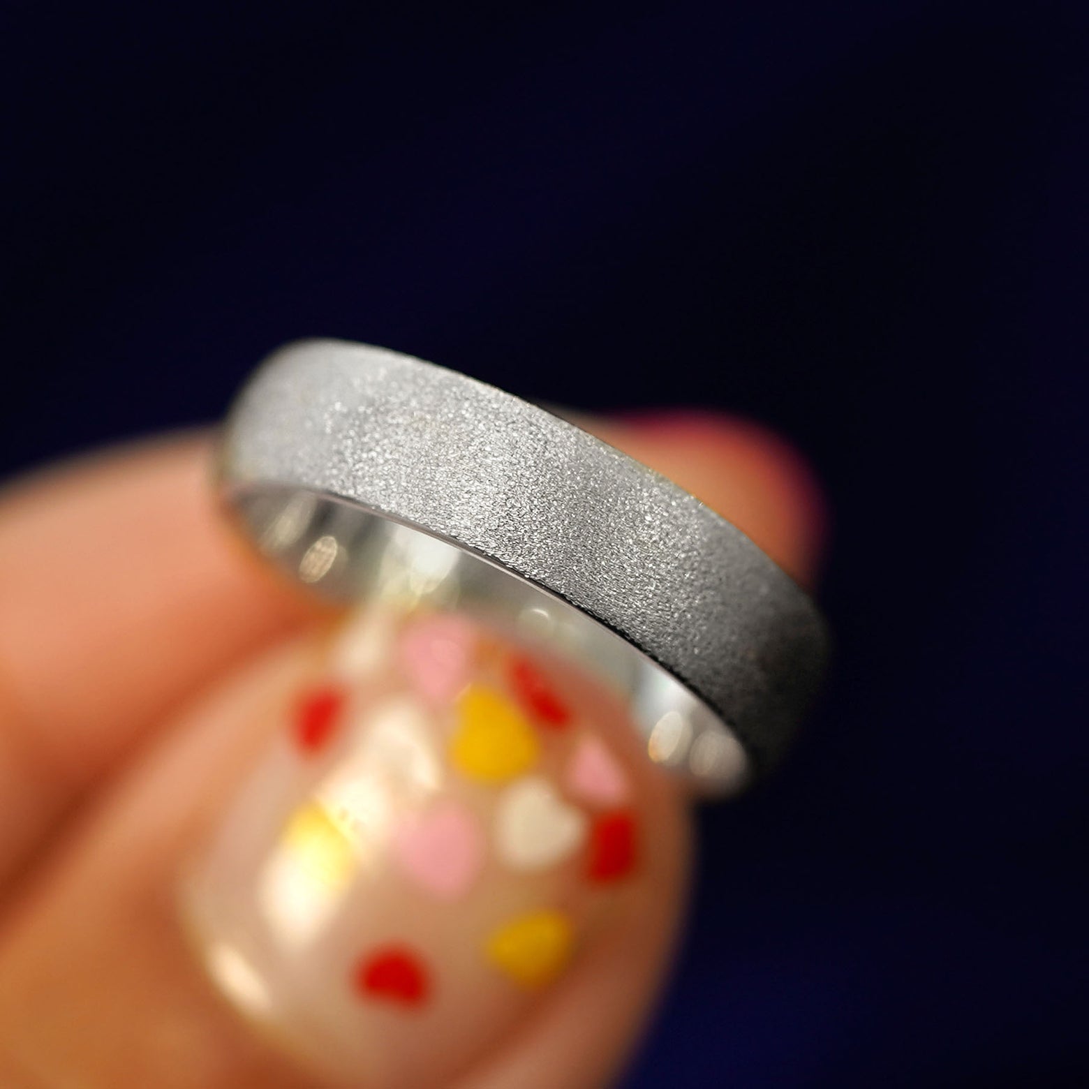 A model holding a Silver Mix Stardust Band tilted to show the side of the ring